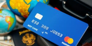 Kreditkarte mit Reiseversicherung und Reiseutensilien.